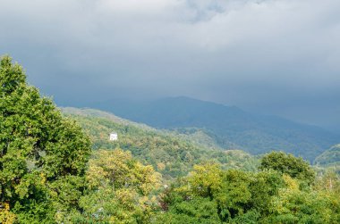 Romanya 'nın Baia Sprie kentinde sonbaharda bir tepedeki beyaz şapelin manzarası