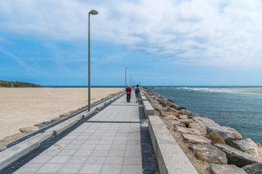 FOZ, SPAIN - 27 AĞUSTOS 2022: İspanya 'nın kuzeybatısındaki Foz, Galiçya kasabasındaki gezinti güvertesinde yürüyen insanlar