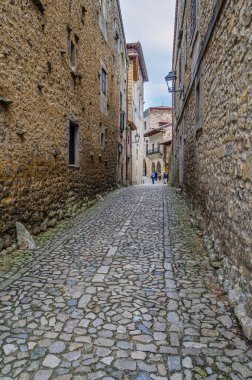 SANTILLANA DEL MAR, İspanya - 2 Mayıs 2014: İspanya 'nın kuzeyinde, Cantabria' nın Santillana del Mar kasabasında dar sokaklarda taş kaldırımlarla gezen turistler