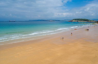 SANTANDER, İspanya - 3 Mayıs 2014: Santander, Cantabria 'daki Sardinero plajında yürüyen insanlar