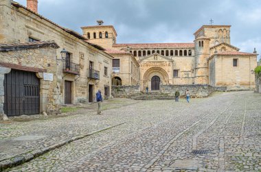 SANTILLANA DEL MAR, İspanya - 2 Mayıs 2014: İspanya 'nın kuzeyinde Santillana del Mar kasabasında Santa Juliana Kolej Kilisesi ve manastırı önündeki turistler
