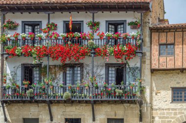 Mimari detaylar, renkli çiçeklerle kaplar, Cantabria 'nın kuzeyindeki Santillana del Mar köyünde dekorasyon pencereleri.