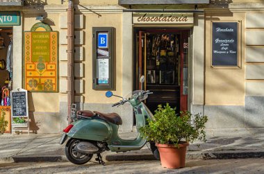REAL SITIO DE SAN ILDEFONSO, SPAIN - OCTOBER 13: Architectural detail, facade of a chocolate shop in the town of Real Sitio de San Ildefonso, Segovia province, Spain, with a motorcycle parked in front clipart