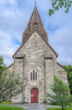 Norveç 'in Vossevangen köyündeki Voss Kilisesi. Gri, taş kilise 1277 'de bilinmeyen bir mimar tarafından çizilmiş planlarla uzun bir kilise tasarımı ile inşa edildi.