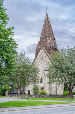 Norveç 'in Vossevangen köyündeki Voss Kilisesi. Gri, taş kilise 1277 'de bilinmeyen bir mimar tarafından çizilmiş planlarla uzun bir kilise tasarımı ile inşa edildi.