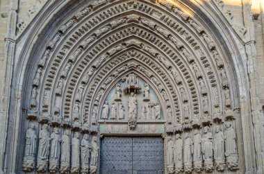 İspanya, Huesca 'daki Gotik Katedrali' nin ana kapısının ayrıntıları. Sergide şehitler, bakireler, melekler ve peygamberlerle süslenmiş büyük bir kemer yer alıyor. 1302 ve 1307 yılları arasında inşa edilmiş.