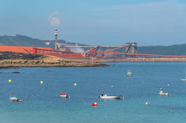 stock image SAN CIBRAO (SAN CIPRIAN), SPAIN - AUGUST 28, 2022: View from the port of San Cibrao, Galicia, Spain, with the manufacturing plant of the Alcoa company in the background. Alcoa is a US company that produces aluminum