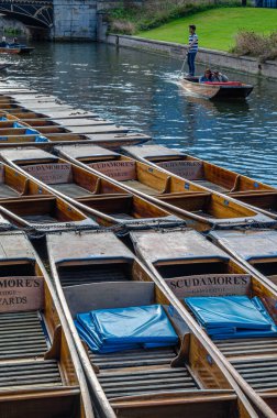 CAMBRIDGE, UNITED KINGDOM - 11 Ekim 2014: Punt 'lar Cambridge, İngiltere' de Cam Nehri üzerinde vuruş yapmak için kullanıldı. Tekne, küçük nehirlerde ve sığ sularda kullanılmak üzere tasarlanmış kare kesimli yayı olan düz tabanlı bir teknedir. Bahisçi tekneyi iterek iter.