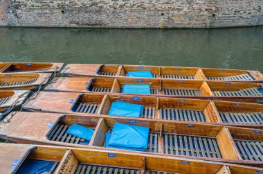 CAMBRIDGE, UNITED KINGDOM - 11 Ekim 2014: Punt 'lar Cambridge, İngiltere' de Cam Nehri üzerinde vuruş yapmak için kullanıldı. Tekne, küçük nehirlerde ve sığ sularda kullanılmak üzere tasarlanmış kare kesimli yayı olan düz tabanlı bir teknedir. Bahisçi tekneyi iterek iter.