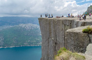 STRAND, NORway - 14 Temmuz 2014: Norveç 'in Rogaland kentinde Preikestolen (Kürsü Kayası) platformundaki insanlar, Lysefjorden' dan 604 metre yükseğe yükselen dik bir uçurum