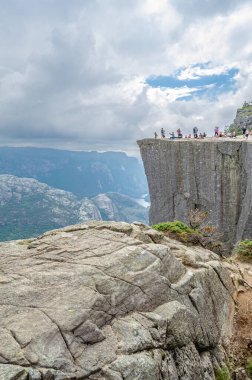 STRAND, NORway - 14 Temmuz 2014: Norveç 'in Rogaland kentinde Preikestolen (Kürsü Kayası) platformundaki insanlar, Lysefjorden' dan 604 metre yükseğe yükselen dik bir uçurum