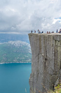 STRAND, NORway - 14 Temmuz 2014: Norveç 'in Rogaland kentinde Preikestolen (Kürsü Kayası) platformundaki insanlar, Lysefjorden' dan 604 metre yükseğe yükselen dik bir uçurum