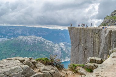 STRAND, NORway - 14 Temmuz 2014: Norveç 'in Rogaland kentinde Preikestolen (Kürsü Kayası) platformundaki insanlar, Lysefjorden' dan 604 metre yükseğe yükselen dik bir uçurum