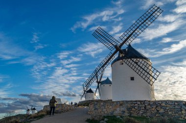 CONSUEGRA, İspanya - 16 Kasım 2019: Ünlü Don Kişot Yolu üzerindeki Toledo ilinin Consuegra köyündeki tipik yel değirmenlerini ziyaret eden turistler