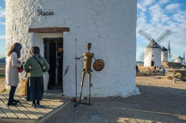 CONSUEGRA, İspanya - 16 Kasım 2019: Ünlü Don Kişot Yolu üzerindeki Toledo ilinin Consuegra köyündeki tipik yel değirmenlerini ziyaret eden turistler