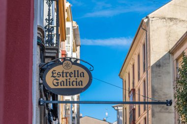 RIBADEO, İspanya - 3 Eylül 2022: Ribadeo, Galiçya 'nın tarihi merkezinde Estrella Galicia birasının yazılı olduğu bir barın işareti