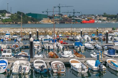 RIBADEO, SPAIN - AUGUST 30, 2022: View of the port of Ribadeo (Galicia), with the shipyards of the port of Figueras (Asturias) in the background, in the Eo estuary, northern Spain clipart