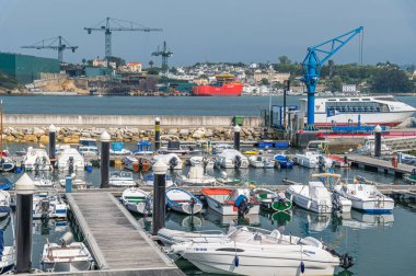 RIBADEO, SPAIN - AUGUST 30, 2022: View of the port of Ribadeo (Galicia), with the shipyards of the port of Figueras (Asturias) in the background, in the Eo estuary, northern Spain clipart