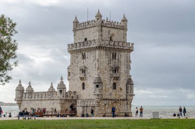 LISBON, PORTUGAL - NOVEMBER 8, 2014: Portekiz 'in Lizbon şehrinde bulunan ünlü Belem Kulesi' ni ziyaret eden insanlar, kireç taşı mimarisinden yapılmış Portekiz Manueline örnekleridir.