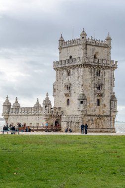 LISBON, PORTUGAL - NOVEMBER 8, 2014: People visiting the famous Belem Tower, a 16th-century fortification located in Lisbon, Portugal, an example of the Portuguese Manueline architecture, made of lioz limestone clipart