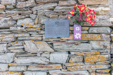 RINLO, SPAIN - SEPTEMBER 1, 2022: Commemorative plaque on a stone wall in the fishing village of Rinlo, Galicia, Spain, in memory of percebeiras (women who fish barnacles) and people who lost their lives in their hard work at sea clipart