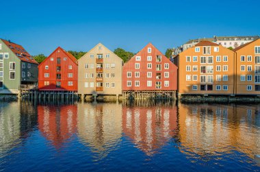 Norveç 'in Trondheim kentindeki Nidelva nehrinin iki yakasındaki eski ahşap depoların manzarası.