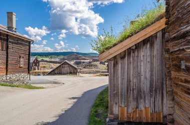 Traditional peat-roofed wooden houses in the mining district of the town of Roros, Norway clipart