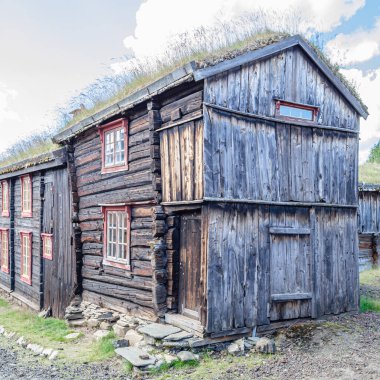 Traditional peat-roofed wooden houses in the mining district of the town of Roros, Norway clipart