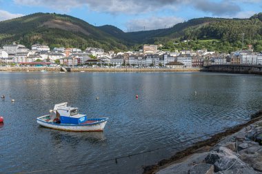 VIVEIRO, İspanya - SEPTEMBER 2, 2022: Limandaki balıkçı tekneleri ve arka plandaki eski Viveiro kasabası, Lugo eyaleti, Galiçya, İspanya