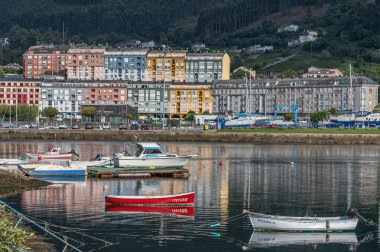 VIVEIRO, İspanya - SEPTEMBER 2, 2022: Limandaki balıkçı tekneleri ve arka plandaki eski Viveiro kasabası, Lugo eyaleti, Galiçya, İspanya