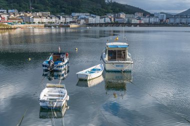 VIVEIRO, İspanya - SEPTEMBER 2, 2022: Limandaki balıkçı tekneleri ve arka plandaki eski Viveiro kasabası, Lugo eyaleti, Galiçya, İspanya