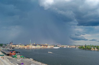STOCKHOLM, SWEDEN - 27 Temmuz 2014: Stockholm, İsveç 'teki şehir manzarası, arka planda fırtına bulutları olan rıhtım binalarının manzarası