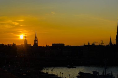 Stockholm, İsveç 'te alacakaranlıkta rıhtımdaki binaların silueti.