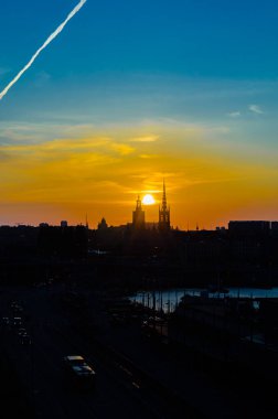 Stockholm, İsveç 'te alacakaranlıkta rıhtımdaki binaların silueti.