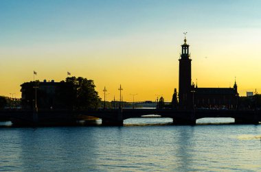 Stockholm, İsveç 'te alacakaranlıkta rıhtımdaki binaların silueti.