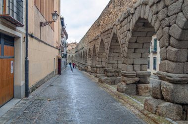 SEGOVIA, İspanya - 22 Aralık 2019: Segovia, Kastilya ve Leon 'un simgesi olan ünlü Roma su kemerini ziyaret eden turistler