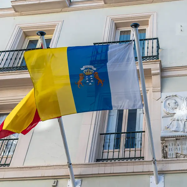 MADRID, İspanya - 6 Kasım 2022: İspanyol oyun yazarı Ricardo de la Vega anısına Madrid 'de bir cephede Kanarya bayrağı ve heykel plaketi