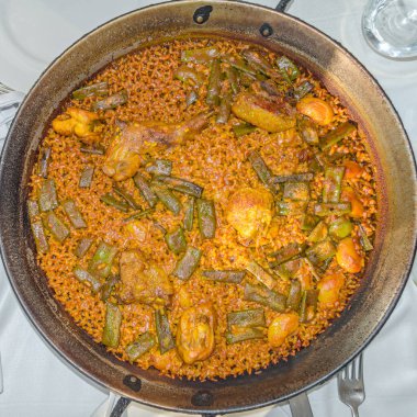 Valencia 'lı tipik bir yemek olan Valencia paella, İspanyol mutfağının en iyi bilinen yemeklerinden biridir. Valencia paella (paella valenciana) 'nın orijinal tarifi olduğuna ve Valencia pilavı (bomba pilavı), zeytinyağı, tavşan, tavuk, sa