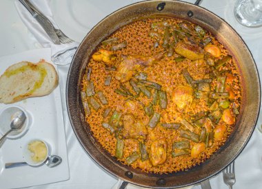 Valencia 'lı tipik bir yemek olan Valencia paella, İspanyol mutfağının en iyi bilinen yemeklerinden biridir. Valencia paella (paella valenciana) 'nın orijinal tarifi olduğuna ve Valencia pilavı (bomba pilavı), zeytinyağı, tavşan, tavuk, sa