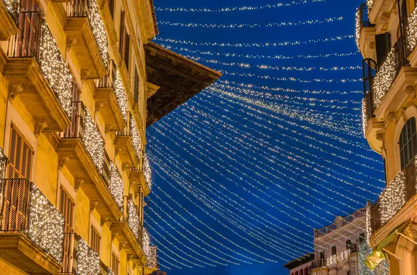 Palma, Mallorca, Balearic Adaları 'nın merkezinde, festival ışıklarıyla süslenmiş Plaza de Cort' un (merkez kare) gece manzarası
