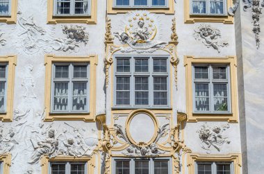 MUNCHEN, GERMANY - 26 HAZİRAN 2015: Münih, Almanya 'da Asamhaus cephesi, Asam kardeşler tarafından 1733' te edinilen 16. yüzyıl Barok yerleşim yeri, sarı bir arka planda beyaz sıva süslemelerini göstermektedir.