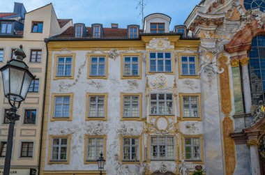 MUNCHEN, GERMANY - 3 HAZİRAN 2015: Münih, Almanya 'da Asamhaus cephesi, Asam kardeşler tarafından 1733' te edinilen 16. yüzyıl Barok yerleşim yeri, sarı bir arka planda beyaz sıva süslemesini gösteren