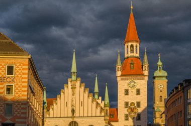 MUNCHEN, GERMANY - 25 Temmuz 2015: Münih, Bavyera 'da bir ortaçağ binası olan Marienplatz merkez meydanının günbatımı manzarası. 1983 yılından bu yana Spielzeugmuseum (Oyuncak Müzesi) 'de sergilenmektedir.)