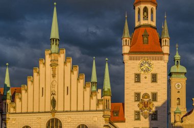 MUNCHEN, GERMANY - 25 Temmuz 2015: Münih, Bavyera 'da bir ortaçağ binası olan Marienplatz merkez meydanının günbatımı manzarası. 1983 yılından bu yana Spielzeugmuseum (Oyuncak Müzesi) 'de sergilenmektedir.)