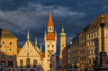 MUNCHEN, GERMANY - 25 Temmuz 2015: Münih, Bavyera 'da bir ortaçağ binası olan Marienplatz merkez meydanının günbatımı manzarası. 1983 yılından bu yana Spielzeugmuseum (Oyuncak Müzesi) 'de sergilenmektedir.)