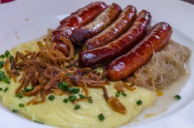 Tipik Alman yemeği, ızgara sosis, lahana turşusu ve patates püresi.