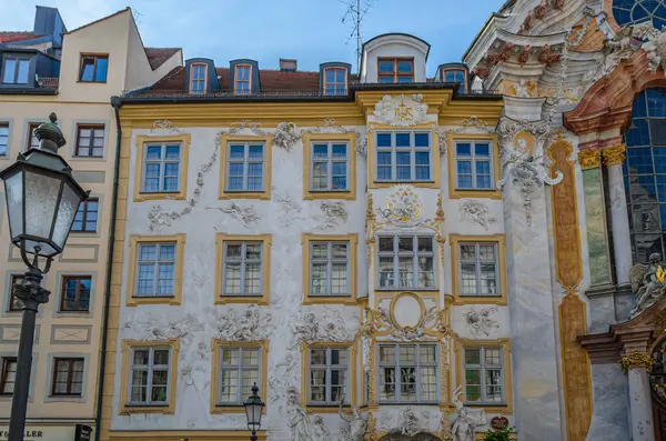 MUNCHEN, GERMANY - 3 HAZİRAN 2015: Münih, Almanya 'da Asamhaus cephesi, Asam kardeşler tarafından 1733' te edinilen 16. yüzyıl Barok yerleşim yeri, sarı bir arka planda beyaz sıva süslemesini gösteren