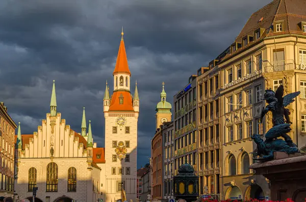 MUNCHEN, GERMANY - 25 Temmuz 2015: Münih, Bavyera 'da bir ortaçağ binası olan Marienplatz merkez meydanının günbatımı manzarası. 1983 yılından bu yana Spielzeugmuseum (Oyuncak Müzesi) 'de sergilenmektedir.)