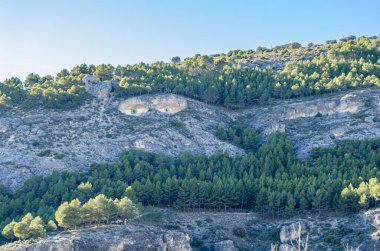 CUENCA, SPAIN - MARCH 28, 2015: Los ojos de la mora (The Eyes of the Moor woman), graffiti painted by Fine Arts students on a mountain outcrop, seen from the town of Cuenca, Spain, in honor of the legend of a forbidden love