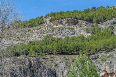 CUENCA, SPAIN - MARCH 28, 2015: Los ojos de la mora (The Eyes of the Moor woman), graffiti painted by Fine Arts students on a mountain outcrop, seen from the town of Cuenca, Spain, in honor of the legend of a forbidden love